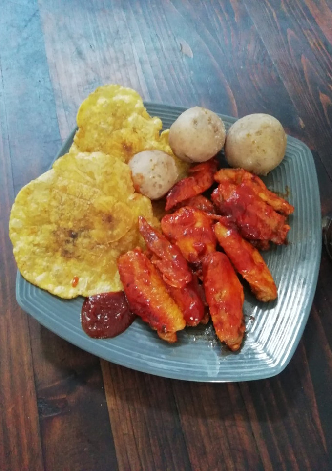 Una foto de Alitas bbq con pataconas y papá salada