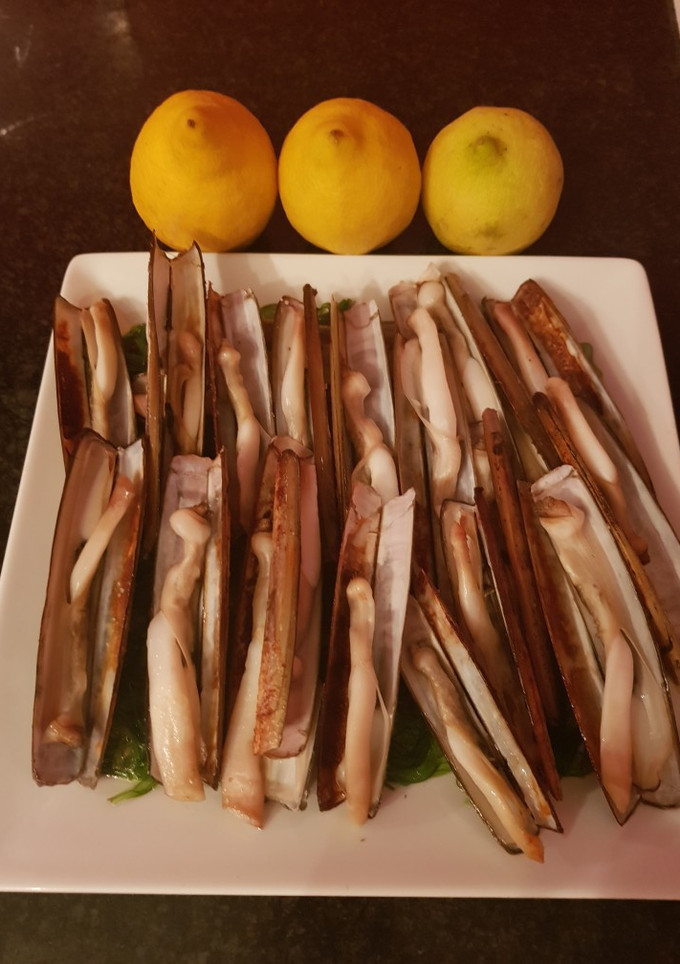 Una foto de Navajas al limón sobre lecho de wakame