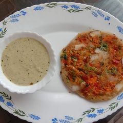 A picture of Veggie Uttapam with Peanut Chutney.