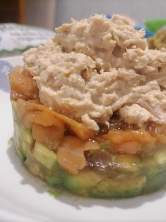 Una foto de Tartar de aguacate, salmón ahumado y mousse de atún
