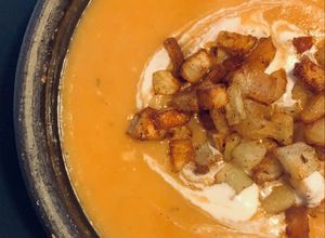 Una foto de Crema de Zapallo c/papas bravas