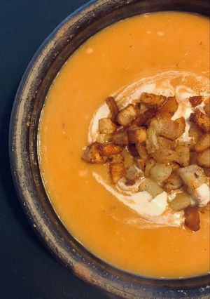 Una foto de Crema de Zapallo c/papas bravas