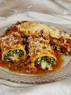 Una foto de Canelones de acelga, queso y ricotta con salsa bolognesa y bechamel. Gratinados 🍷🍽️