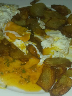Una foto de Patatas fritas con huevos y salsa chimichurri