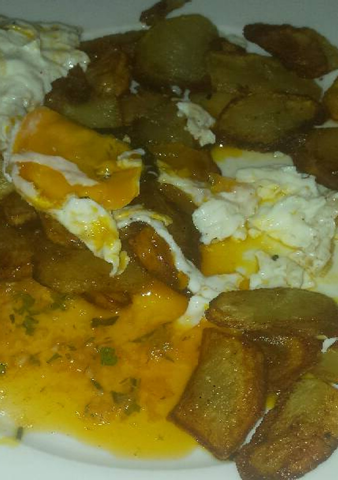 Una foto de Patatas fritas con huevos y salsa chimichurri