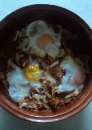Una foto de Otros chilaquiles de chiles secos, pollo, hoja santa, pulque y huevos estrellados