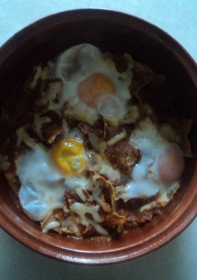 Una foto de Otros chilaquiles de chiles secos, pollo, hoja santa, pulque y huevos estrellados