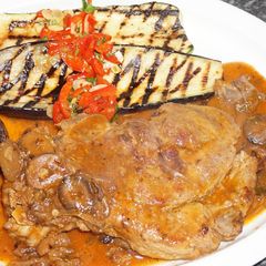 A picture of Marbled pork chops braised in merlot wine sauce.