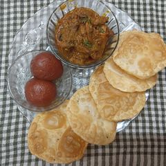 A picture of Bengali Simple Dinner Thali (Luchi, Chicken Kosha, Pantua).