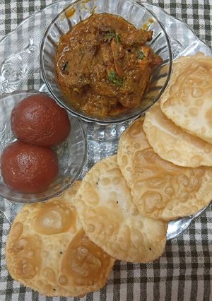 A picture of Bengali Simple Dinner Thali (Luchi, Chicken Kosha, Pantua).