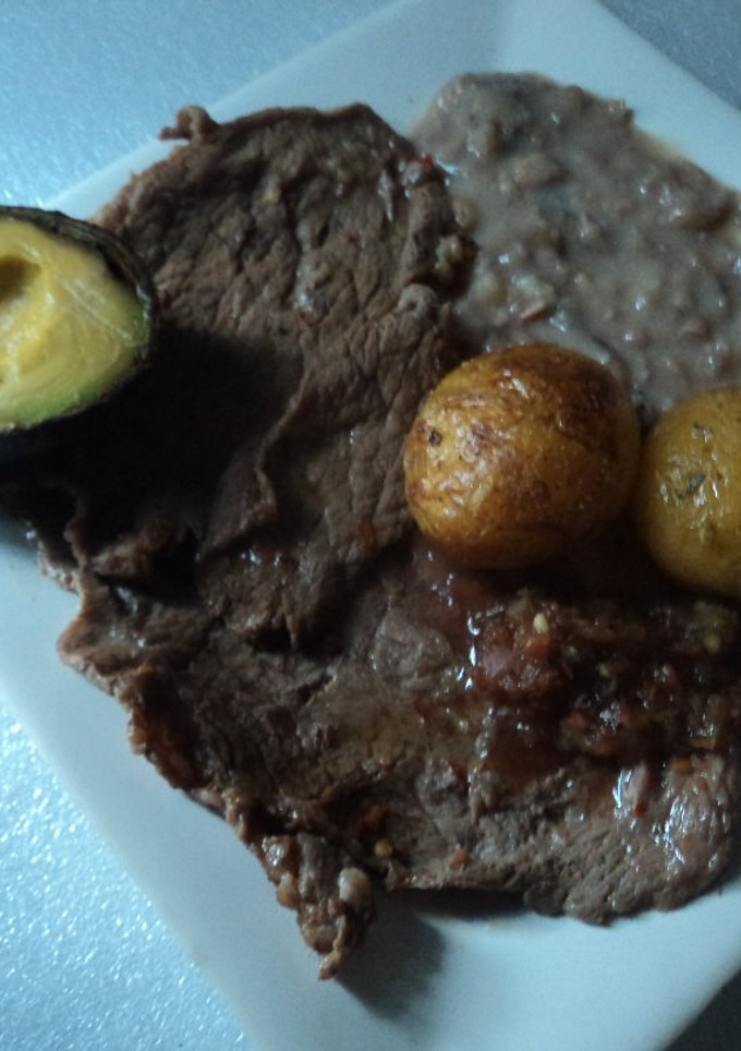 Una foto de Carne asada al pulque con frijolitos, papas asadas y salsa martajada ranchera San Diego