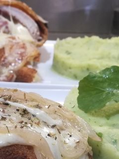 Una foto de Suprema de pollo rellena, a la fugazzeta, puré de papa y rúcula