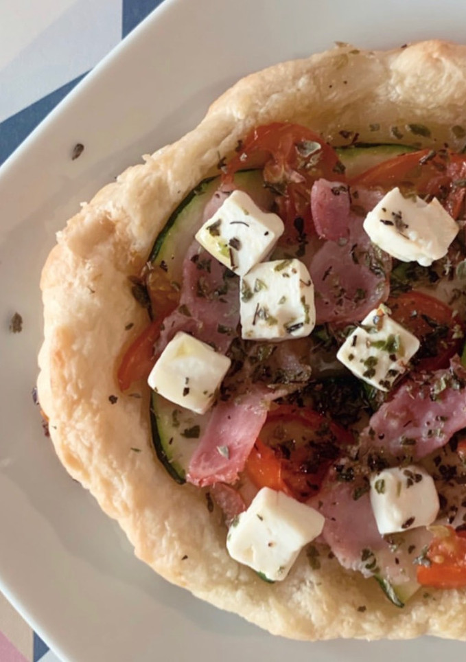 Una foto de Hojaldre con calabacín, tomate cherry, bacon, queso feta y orégano