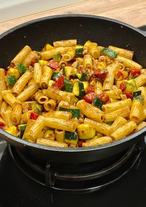 Una foto de Pasta corta con pollo y calabacín al ajo negro