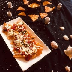 A picture of Veg Nachos with cheesy Dip.