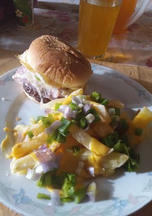 Una foto de Hamburguesa con papas fritas cheddar y verdeo
