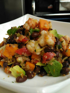 Una foto de Frijoles negros con calabaza, langostinos y aguacate