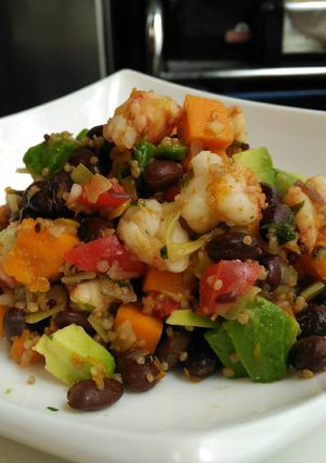 Una foto de Frijoles negros con calabaza, langostinos y aguacate