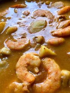 Una foto de Patatas con sepia y langostinos