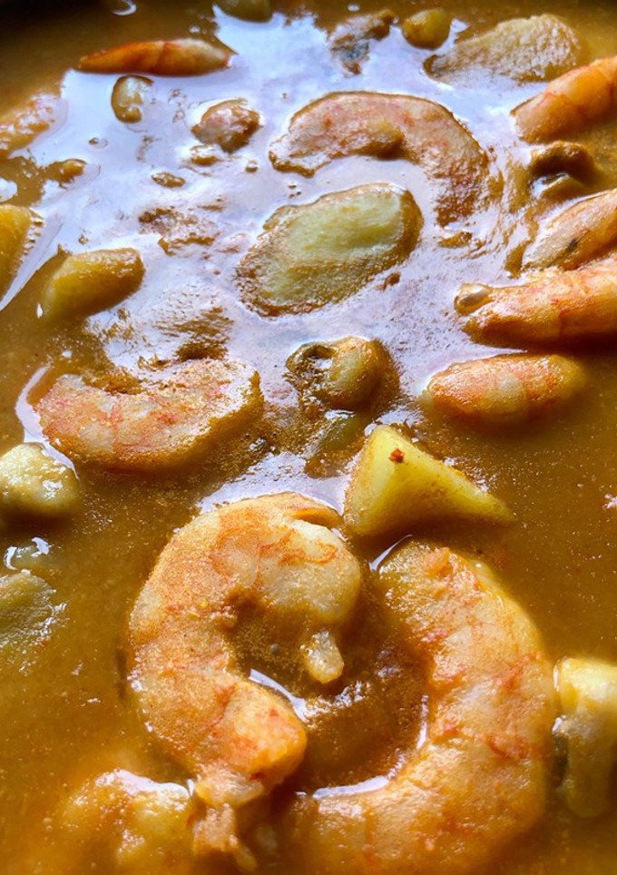 Una foto de Patatas con sepia y langostinos