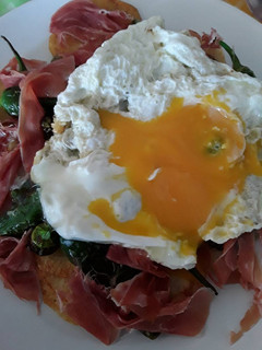 Una foto de Huevos rotos con jamón y pimientos de Padrón