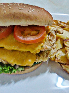 Una foto de Hamburguesa de pollo broaster con queso cheddar y vegetales