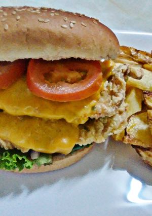 Una foto de Hamburguesa de pollo broaster con queso cheddar y vegetales