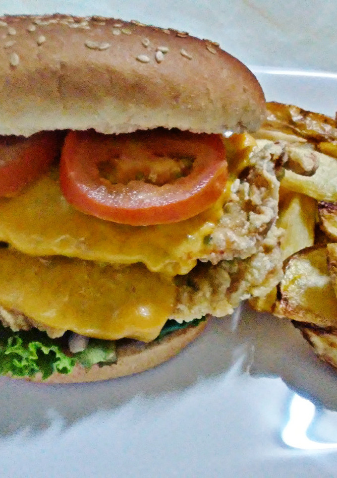 Una foto de Hamburguesa de pollo broaster con queso cheddar y vegetales