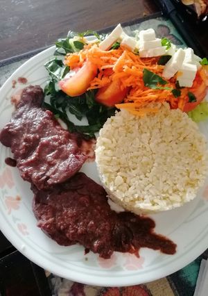 Una foto de Cerdo en salsa de vino con arroz ajonjolí y ensalada