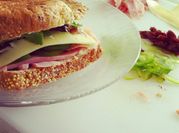 Una foto de sandwich de jamón y rúcula