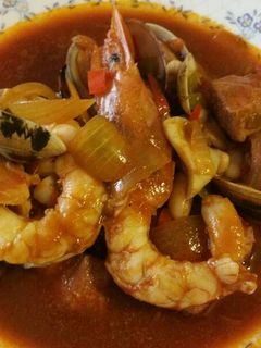 Una foto de Atún con calamares, gambones y almejas en salsa americana