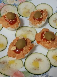 Una foto de Huevos rellenos de atún, con carpaccio de calabacín