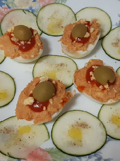 Una foto de Huevos rellenos de atún, con carpaccio de calabacín