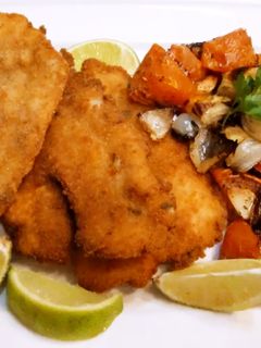 Una foto de Merluza rebozada con mix de verduras al horno