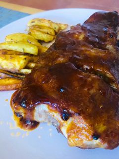 Una foto de Costillas bbq y miel con patatas deluxe