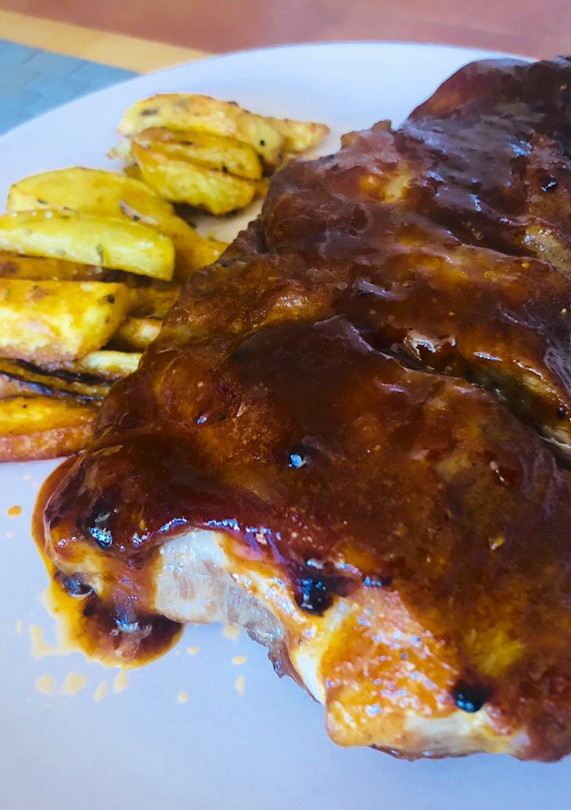 Una foto de Costillas bbq y miel con patatas deluxe