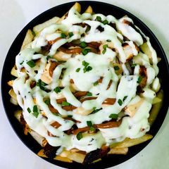 A picture of Creamy Chicken loaded fries with homemade cheese sauce.