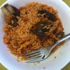 A picture of Jollof rice and fried meat.