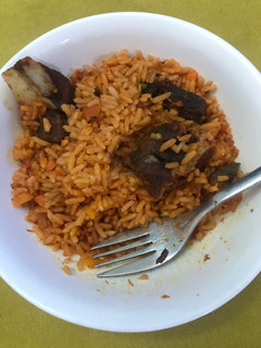 A picture of Jollof rice and fried meat.