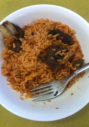 A picture of Jollof rice and fried meat.