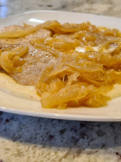 Una foto de Lomo de cerdo encebollado con puré de patatas