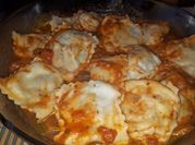 Una foto de raviolis con pollo y queso