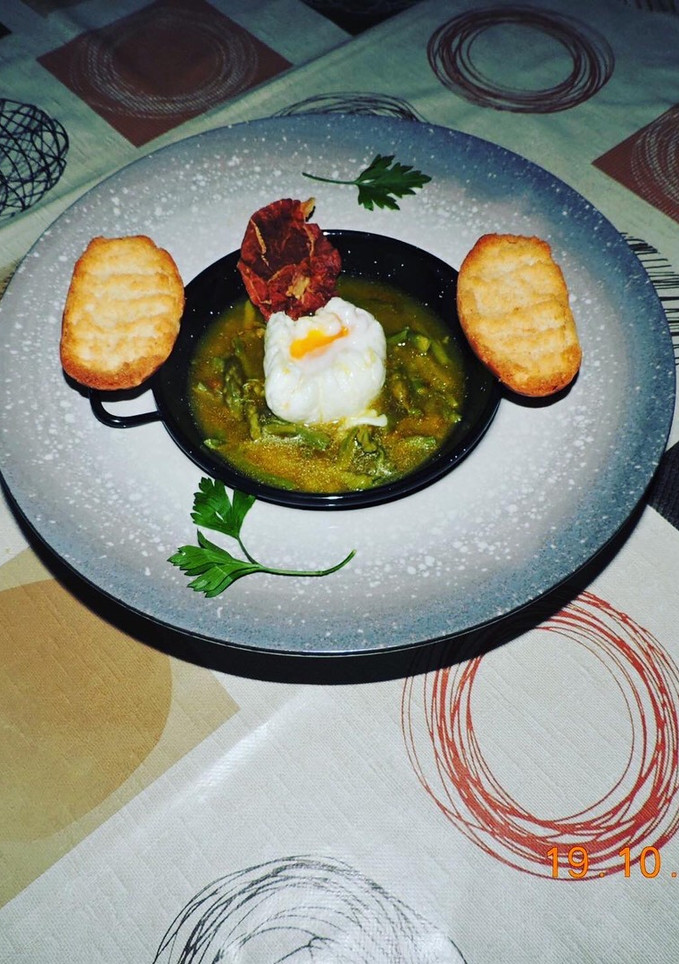 Una foto de Caldillo o sopa de espárragos con huevo poche y crujiente de jamón