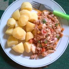A picture of Irish potatoes with corn beef sauce and veggies.