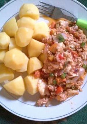 A picture of Irish potatoes with corn beef sauce and veggies.