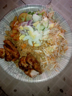 A picture of Jallof Rice with coslow n pepper chicken.