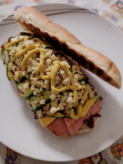 A picture of Gourmet Hot Dog with Caramelized Onions, Cheddar, Grilled Zucchini, Scrambled Egg, and Mustard.