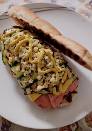 A picture of Gourmet Hot Dog with Caramelized Onions, Cheddar, Grilled Zucchini, Scrambled Egg, and Mustard.