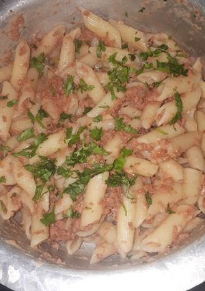 A picture of Penne in corned beef garnished with dhania.