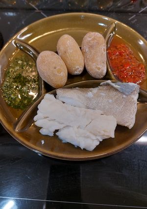 Una foto de Bacalao con papas arrugadas a los dos mojos, verde de cilantro y rojo palmero